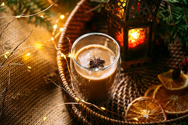 Café navideño con naranja seca en una canasta con guirnaldas y ramas de abeto