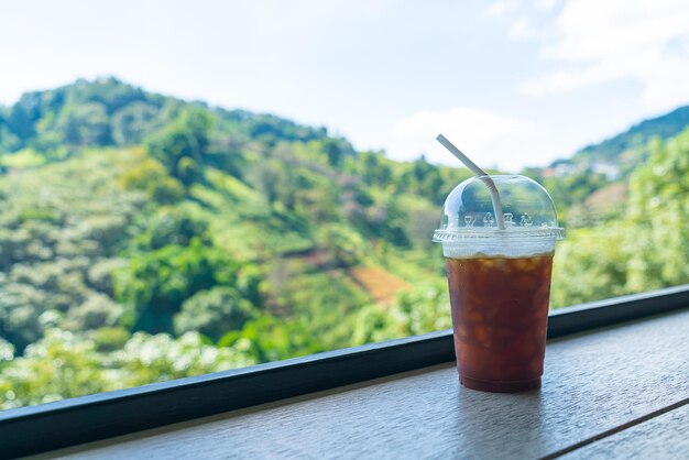 Café negro en la barra de madera con fondo de montaña