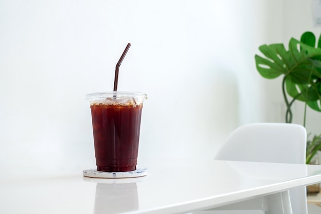 Café negro Café americano en una taza de café de plástico sobre una mesa blanca en el espacio de copia de la cafetería