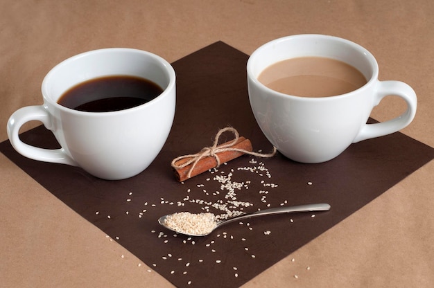 Café negro y café con leche en tazas blancas Canela y sésamo