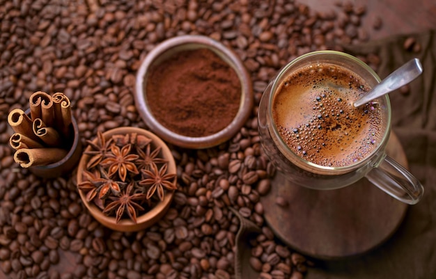 Café negro caliente y granos de café en la mesa de madera vieja