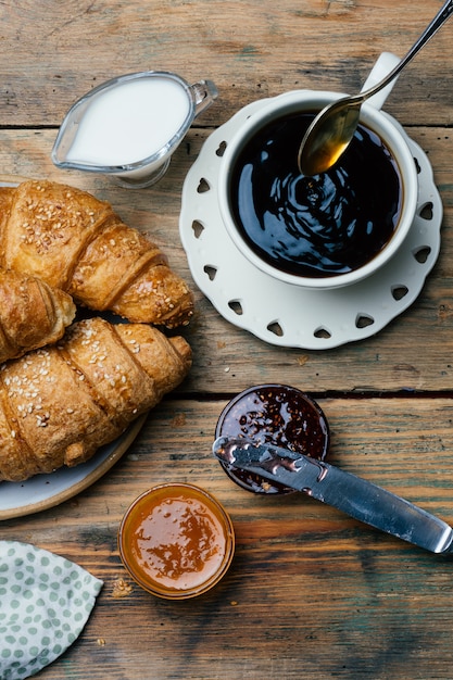 Café negro y cruasanes con mermelada. Desayuno típico francés (Petit Déjeuner)