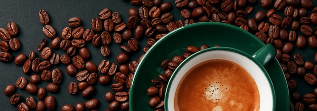 Café negro fuerte en una taza de color esmeralda sobre un fondo negro mate