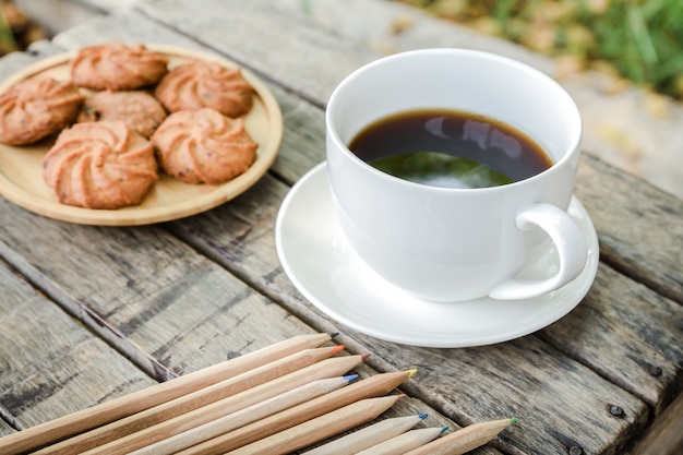 Café negro y galletas en la mesa de madera