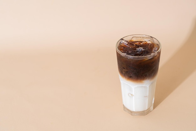 café negro helado con capa de leche en vaso