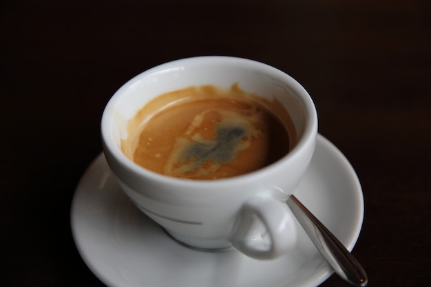 Café negro sobre fondo de madera en la cafetería.