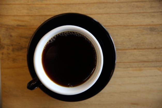 Café negro sobre fondo de madera en la cafetería.