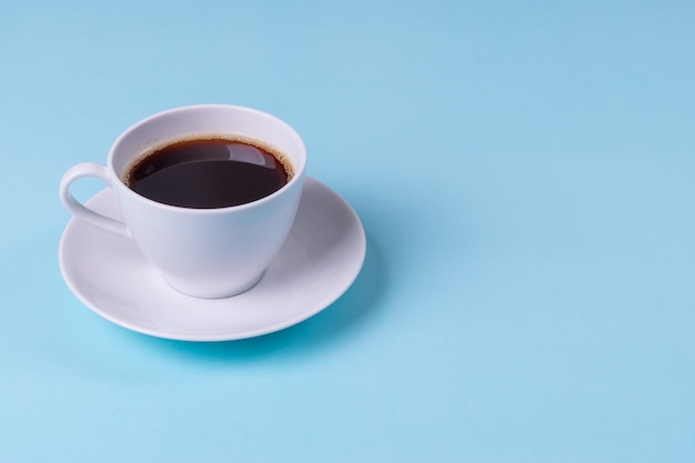 Café negro sobre fondo de mesa azul pálido