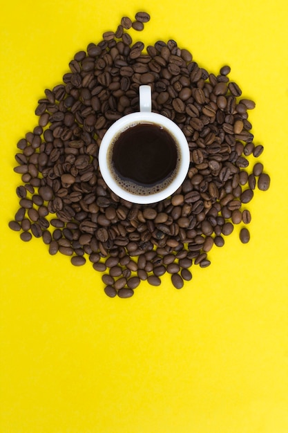 Café negro en la taza blanca y granos de café. Copie el espacio. Vista superior.