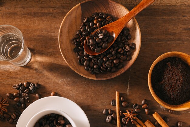 Café negro en una taza en la superficie de los granos de café en una composición con accesorios
