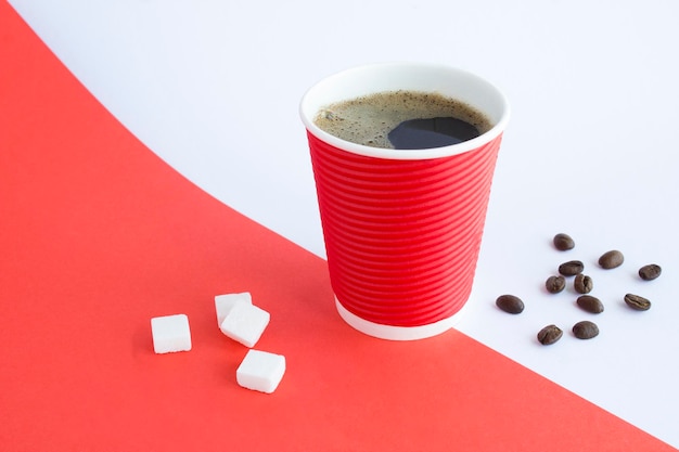 Café negro en el vaso de papel rojo desechable en el fondo de color Espacio de copia de primer plano