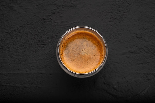 Café negro en un vaso sobre un fondo oscuro