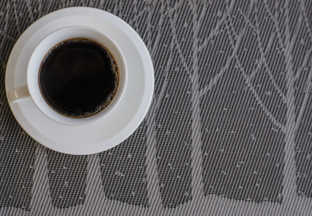 Café negro en la vista superior de la mesa gris con espacio de copia