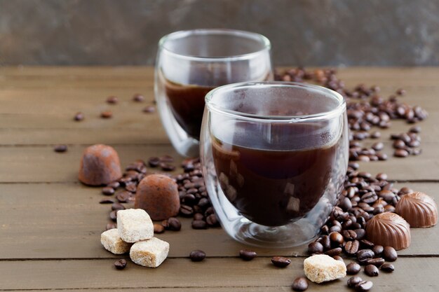 Café no vidro de paredes duplas em uma mesa de madeira.