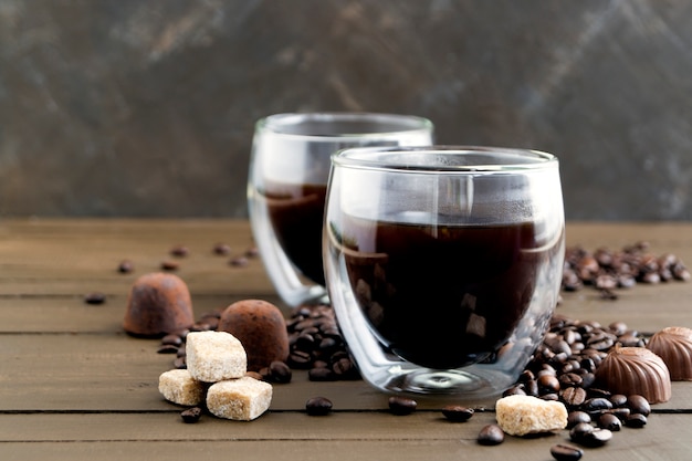 Café no vidro de paredes duplas em uma mesa de madeira.