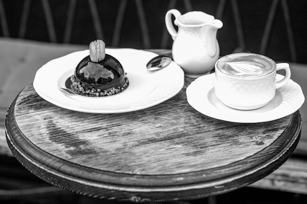 Café o taza de café en la cafetería por la mañana Me encanta el café Taza de capuchino fresco Pastel de chocolate Primer plano Sabroso pastel de chocolate Blanco y negro