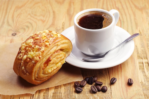 Café y pan con queso en la mesa de madera de cerca