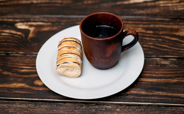 Café y pastel para el desayuno sobre fondo de madera