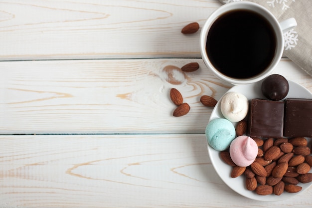 Café preto com doces e amêndoas.