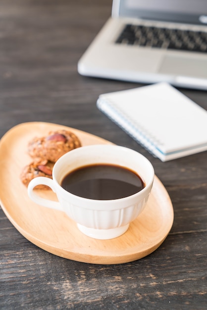 café preto e biscoitos com laptop e livro de nota