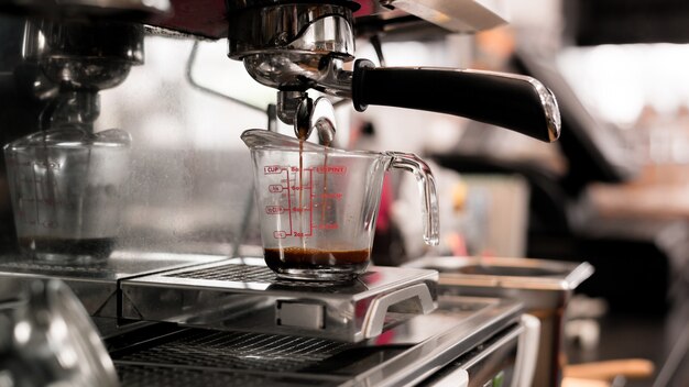 café preto em copo medidor colocado na cafeteira