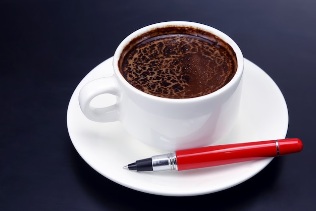 Café preto em uma alça de xícara branca e pires