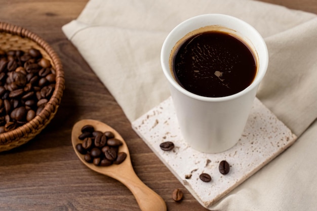 Café preto em uma caneca de café branca em uma mesa de madeira Café preto forte
