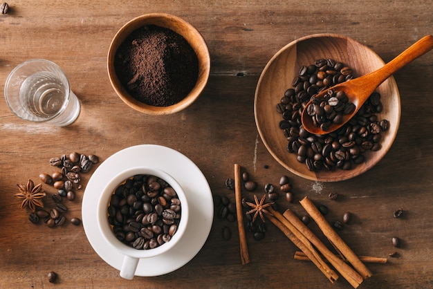 Café preto em uma xícara na superfície dos grãos de café em uma composição com acessórios