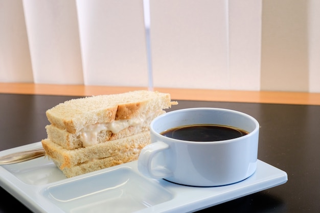 Café preto quente em copo azul com sanduíche Pão branco quente para snack lanche em seminário