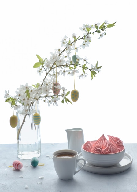 Café de primavera y dulces en una mesa de madera con ramita de árbol cubierto de flores