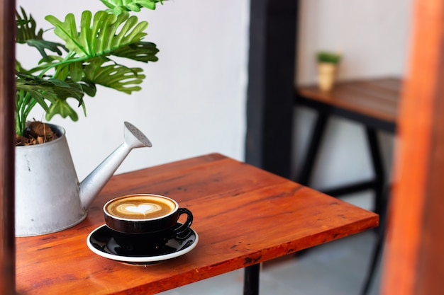 Café quente com arte latte em forma de coração.