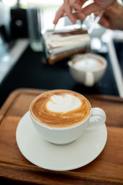 Café quente com latte art na mesa de madeira, hora de relaxar