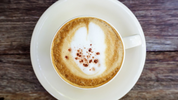 Café quente do cappuccino em um copo branco.