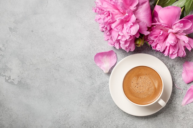 Café quente e flores de peônia rosa