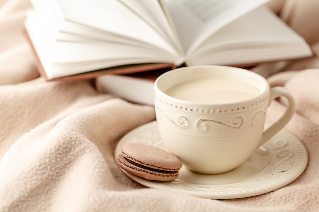 Café quente e livro sobre fundo de lã