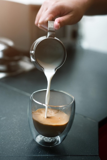 Café quente em uma mesa com creme sendo derramado mostrando a textura