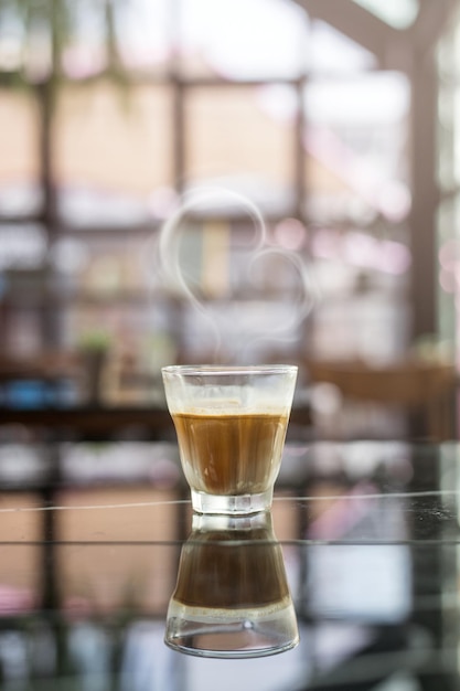 Café quente em uma mesa com creme sendo derramado mostrando a textura