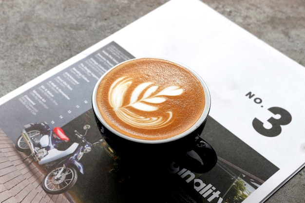 Café quente fechado na revista com foco suave e luz de fundo