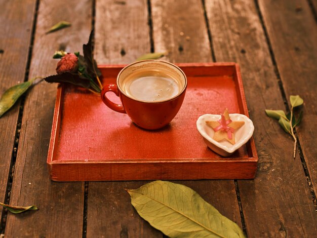 Un café recién hecho en una bandeja de madera roja