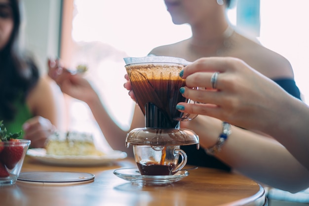 Café recién hecho en la mesa con equipo de filtrado con café molido. Cafetería