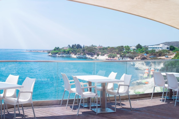 Café restaurante a orillas del mar Mediterráneo Mesas en la terraza bajo los rayos del sol