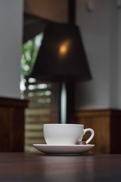 Foto café en una taza blanca con dulces en una mesa de madera en un restaurante