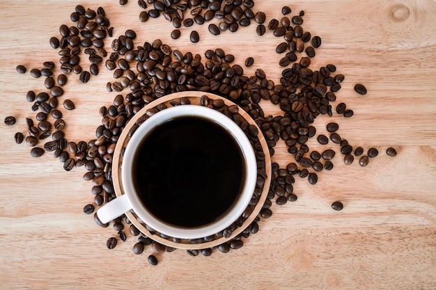 Café en taza blanca en la mesa de madera en la cafetería