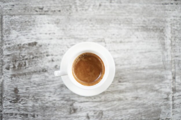 Café en una taza blanca en una mesa de madera grunge