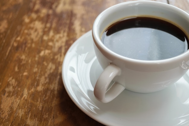 Café en taza blanca en la mesa de madera