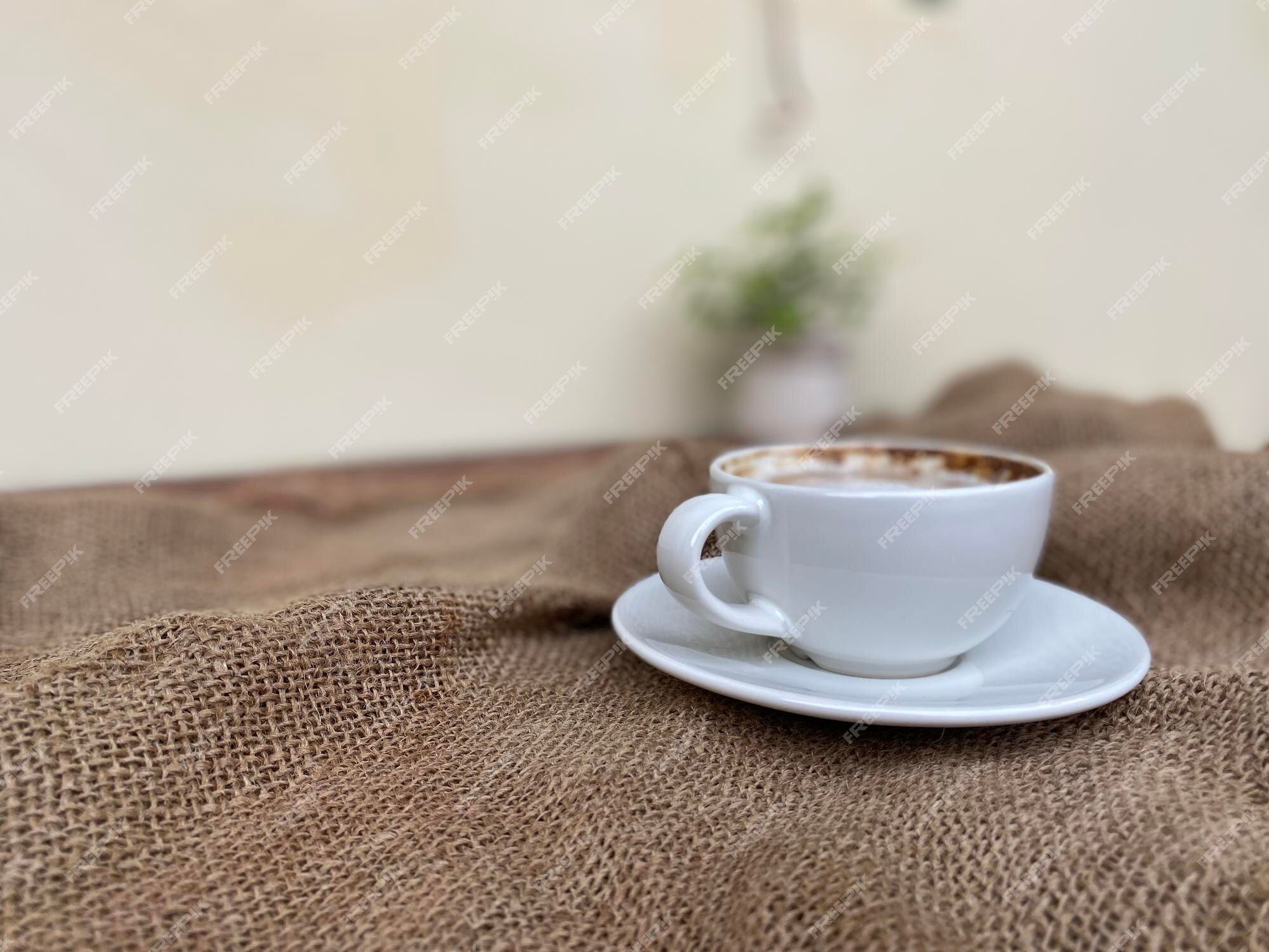 Un vaso de café caliente en la mesa de madera