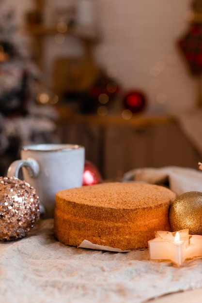 café en una taza de diseño y pastel de miel casero en una mesa de madera en un ambiente de Año Nuevo