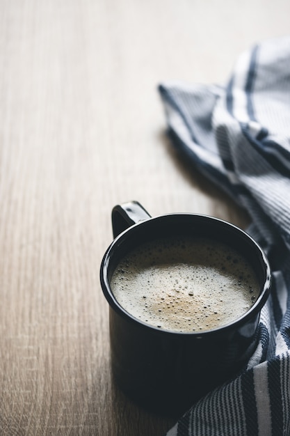 Un café en una taza oscura para acampar.