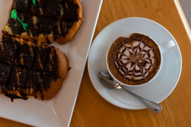 Café en una taza y pan con chocolate.