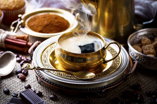 Café en una taza y platillo con granos de café.